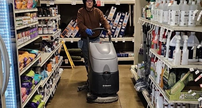AtlantCare technician running a floor scrubber along a retail store aisle