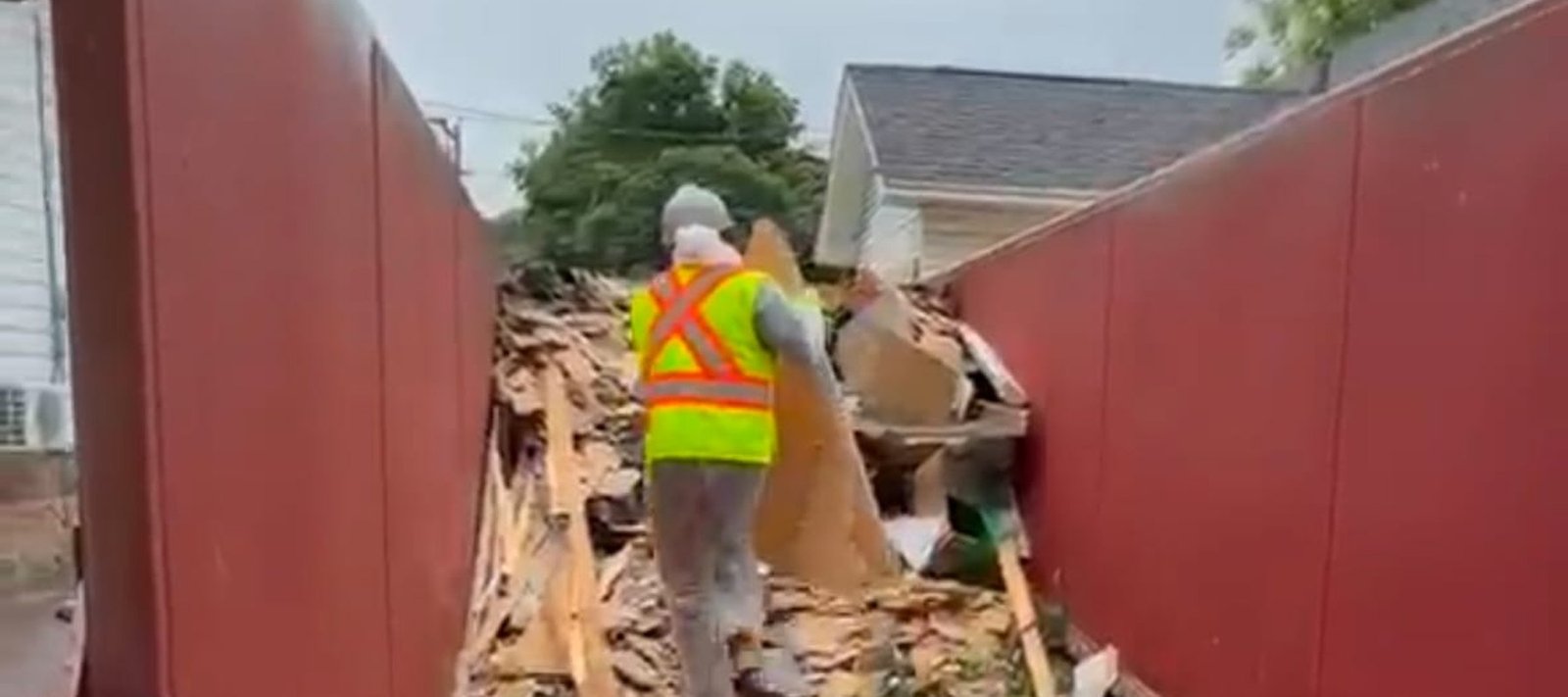 AtlantCare worker clearing construction debris into a disposal bin